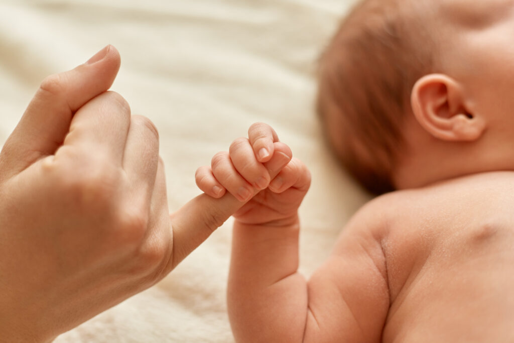 Baby hÃ¤lt einen Finger der Mutter