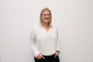 Eine Frau mit blonden Haaren steht vor einer Wand|Ärztin Yvonne Hofer